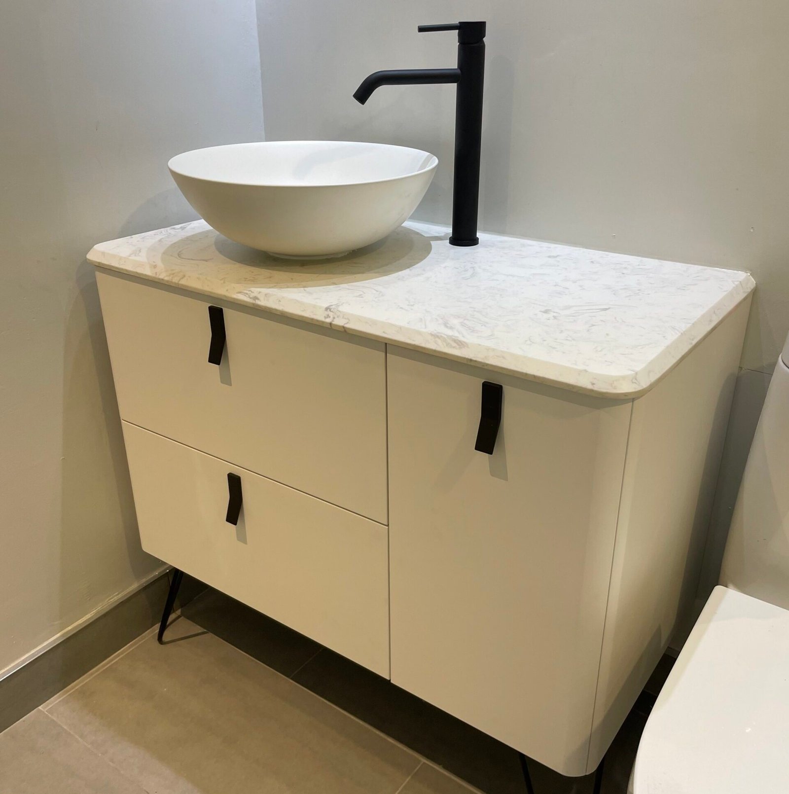 Un mobilier de salle de bain blanc avec armoires et lavabo.