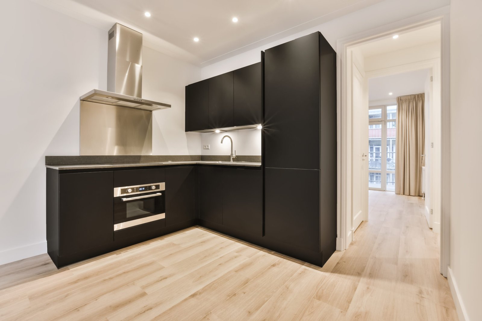 Une cuisine d'appartement avec des armoires noires.