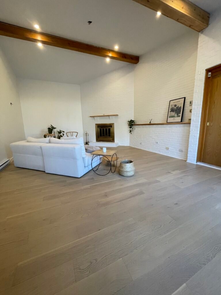 salon avec sofa blanc, foyer et des étagères de bois
