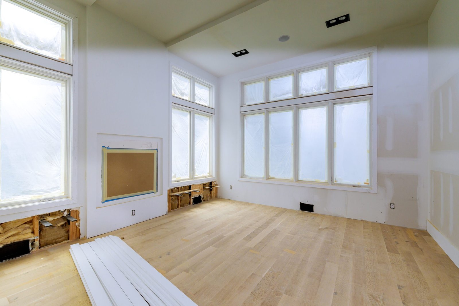 Une maison en cours de rénovation avec des fenêtre donnant vue sur l'extérieur.